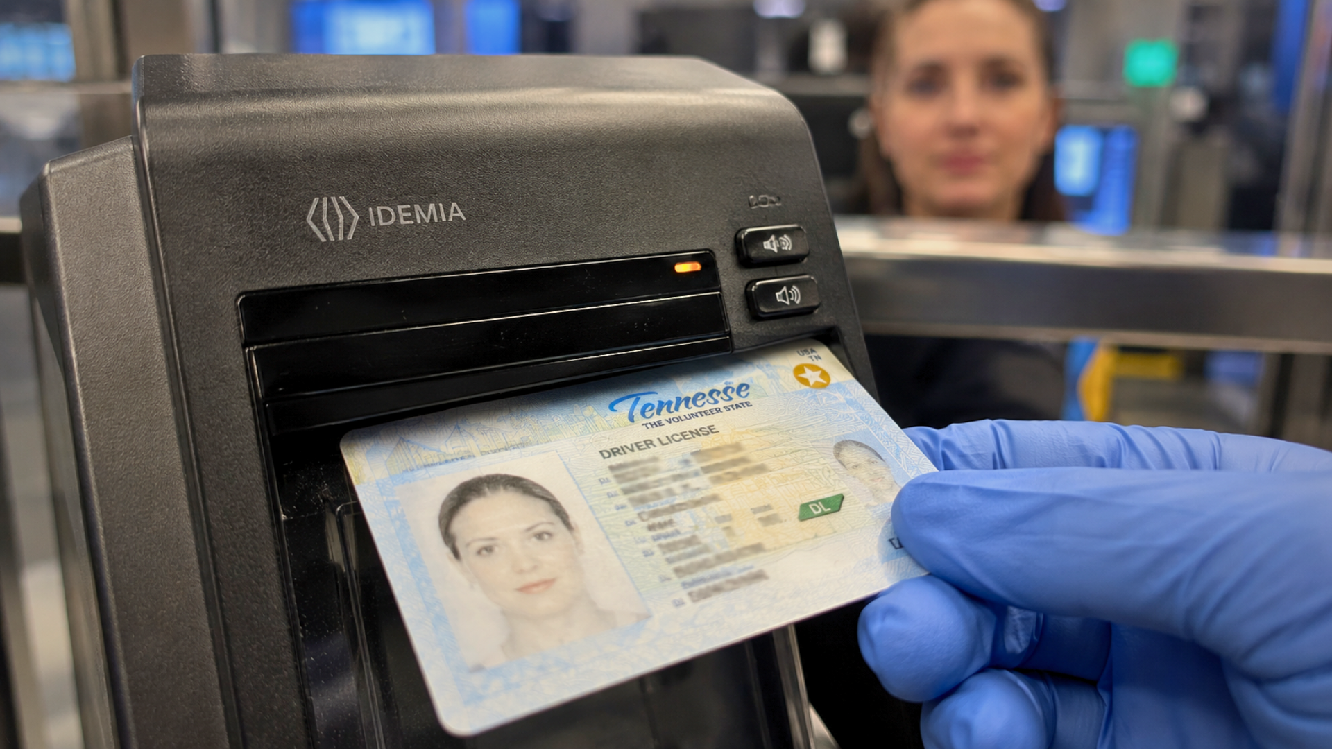 A gloved hand inserting a Tennessee driver's license into an Idemia credential authentication reader at security.