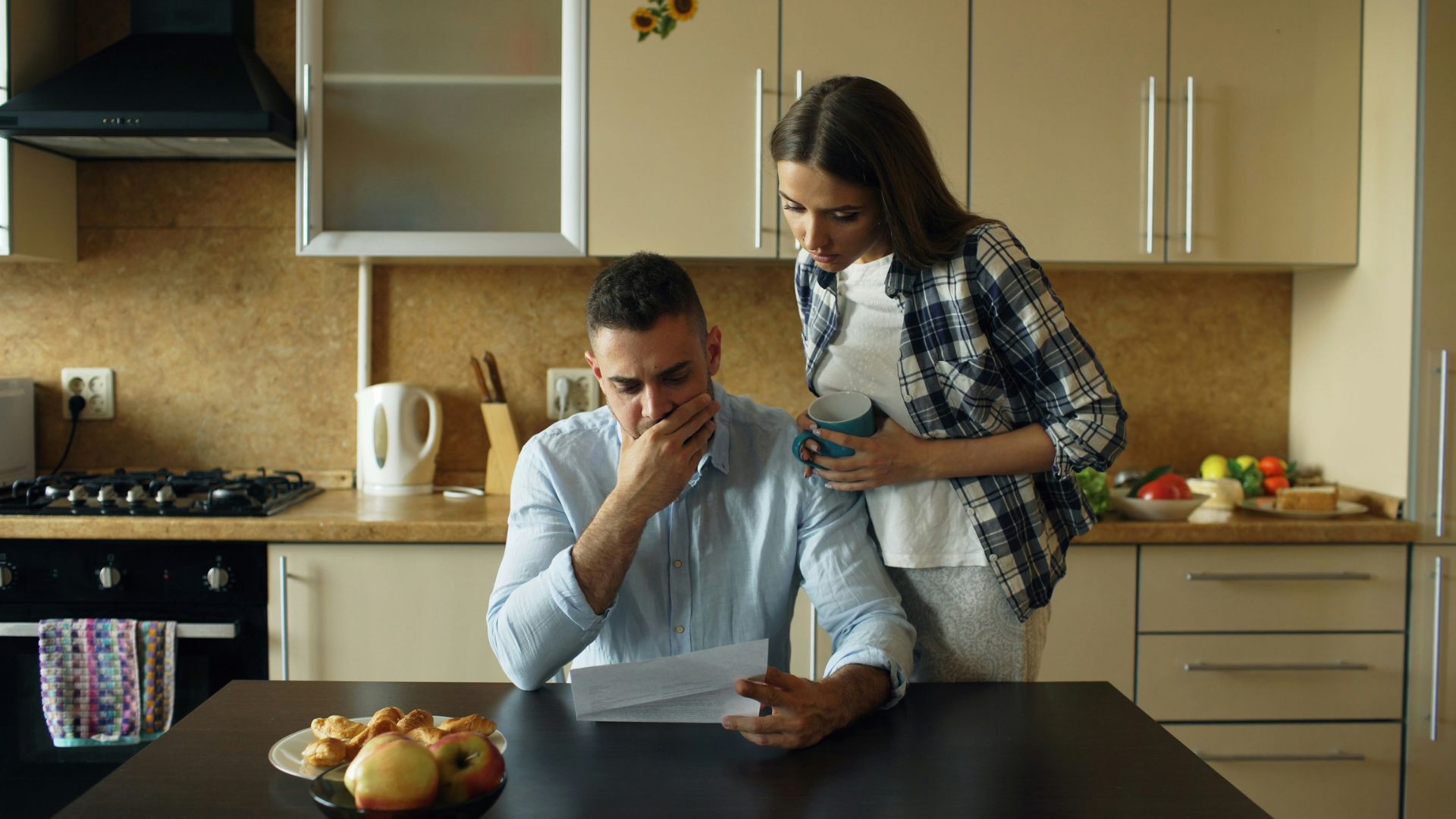 A couple reviewing paperwork together with concerned expressions.
