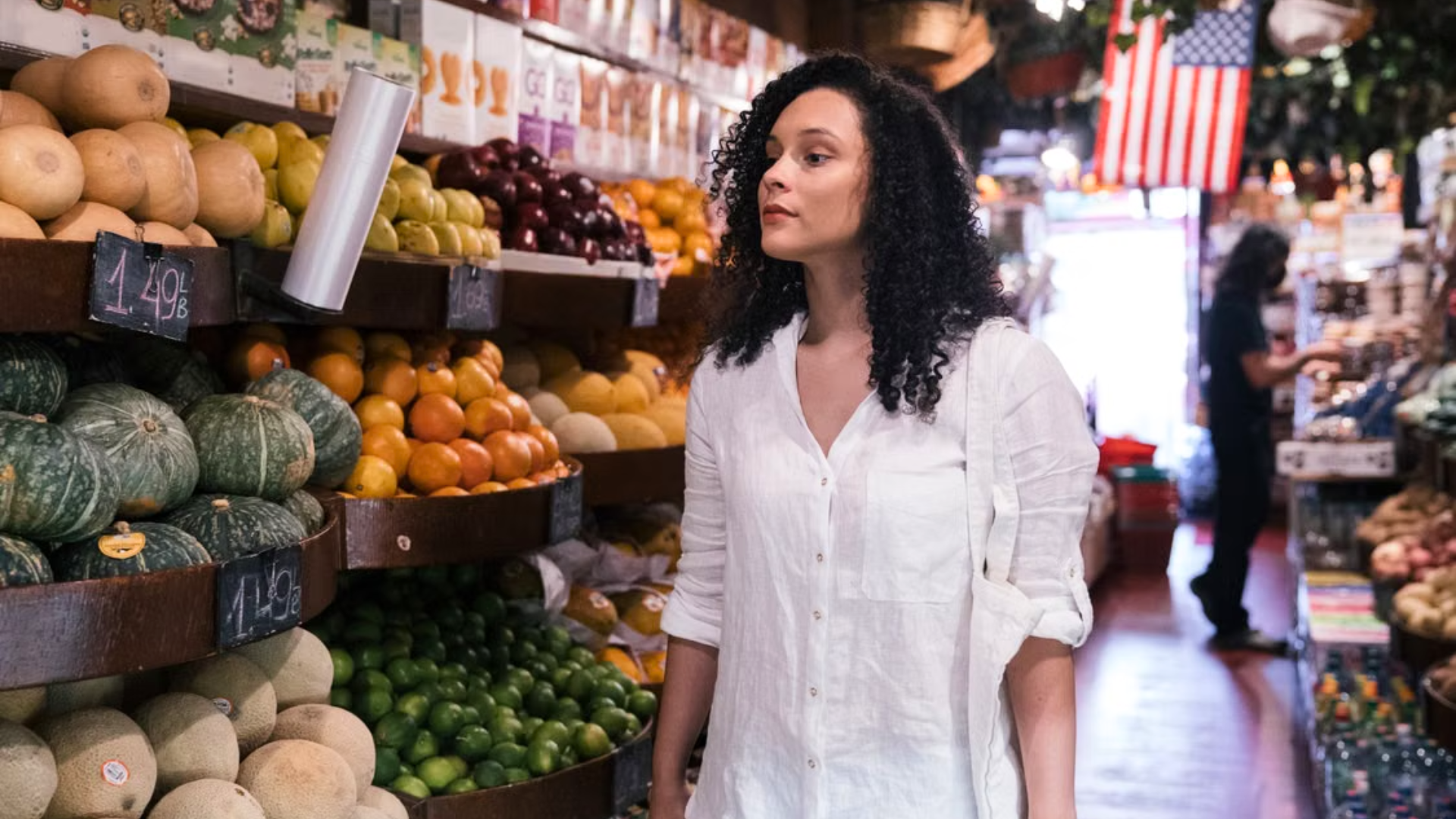 Woman looking at produce in a grocery store.