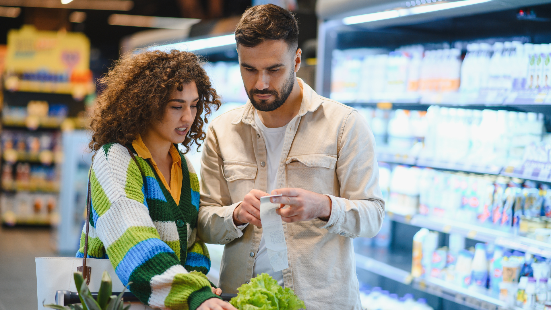 Couple looking at a receipt in a supermarket.