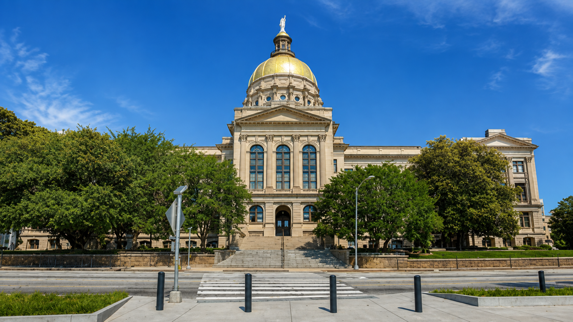 The exterior of the Georgia State Capitol building with its gold dome under a blue sky.