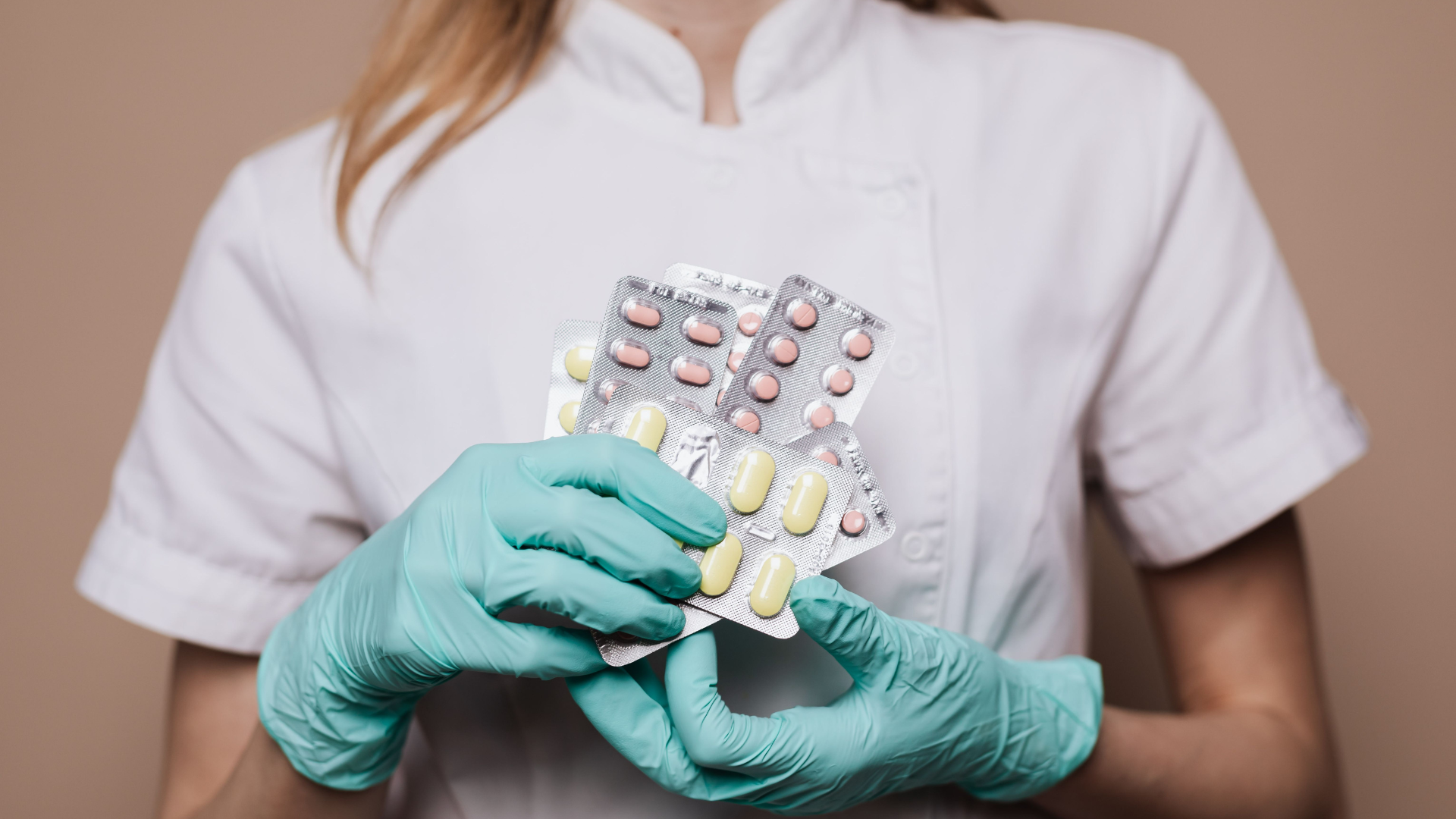 A pharmacist holds a medication, representing new antiviral options after exposure or a positive test.