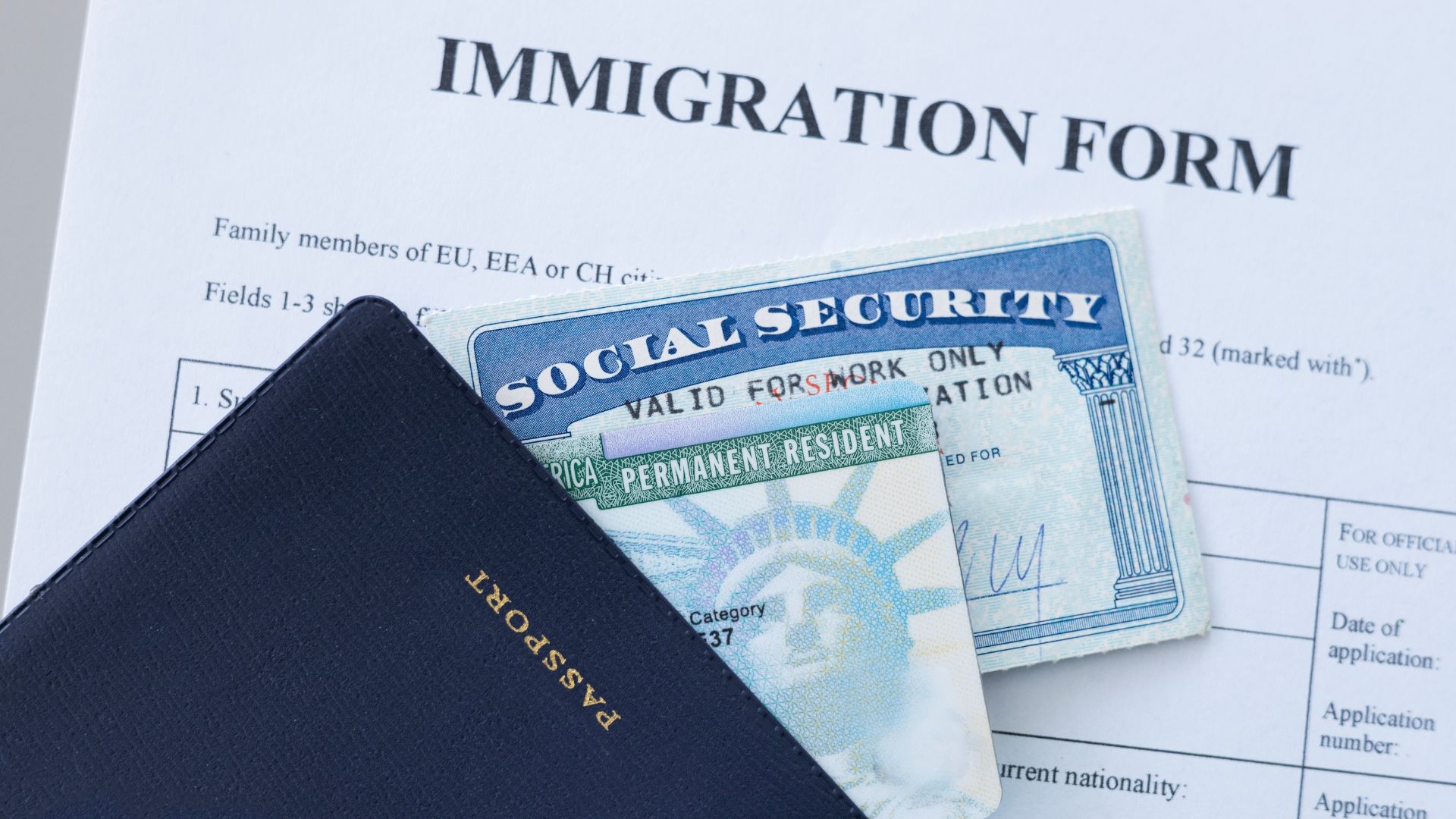 Passport, Social Security card, and immigration form laid together.