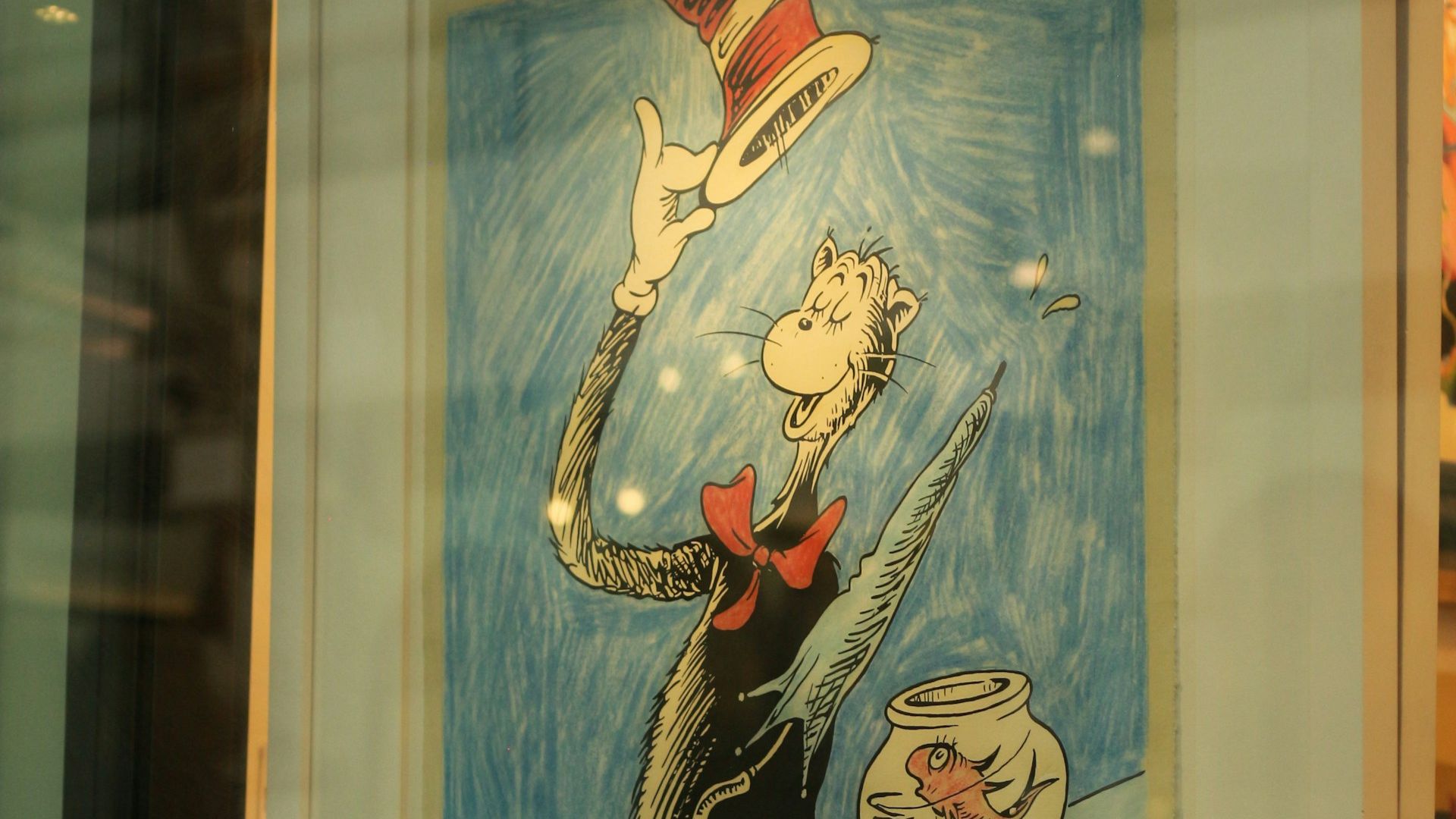 Framed illustration of the Cat in the Hat holding his hat beside a fishbowl.