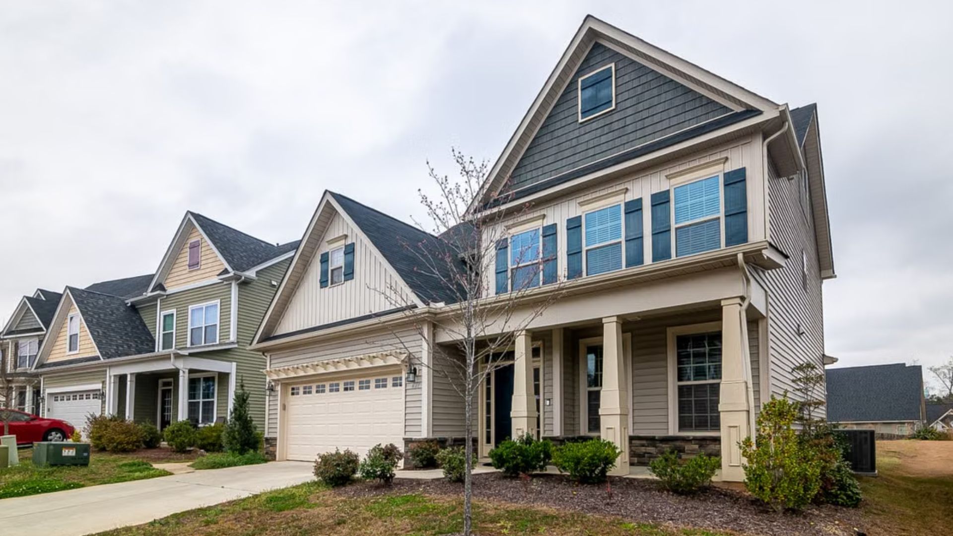 Row of suburban homes with garages and front porches in a residential neighborhood.