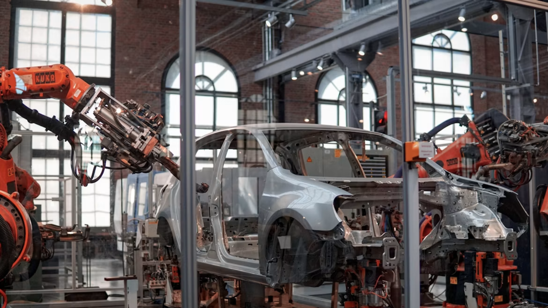 Robotic arms assembling a car chassis on an automated factory manufacturing line.