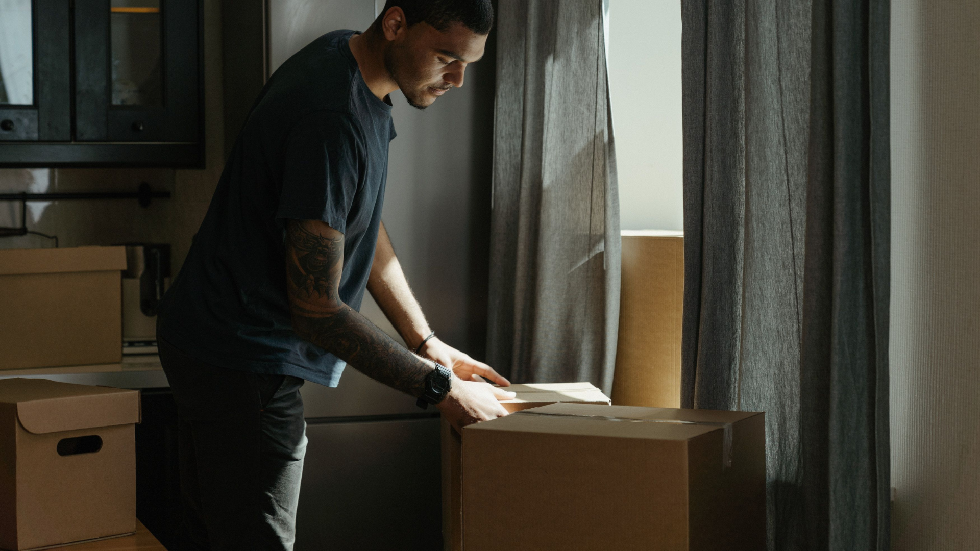 A young renter unpacks in a modest spare room, illustrating the short-term, budget-driven housing arrangements young New Yorkers are turning to.