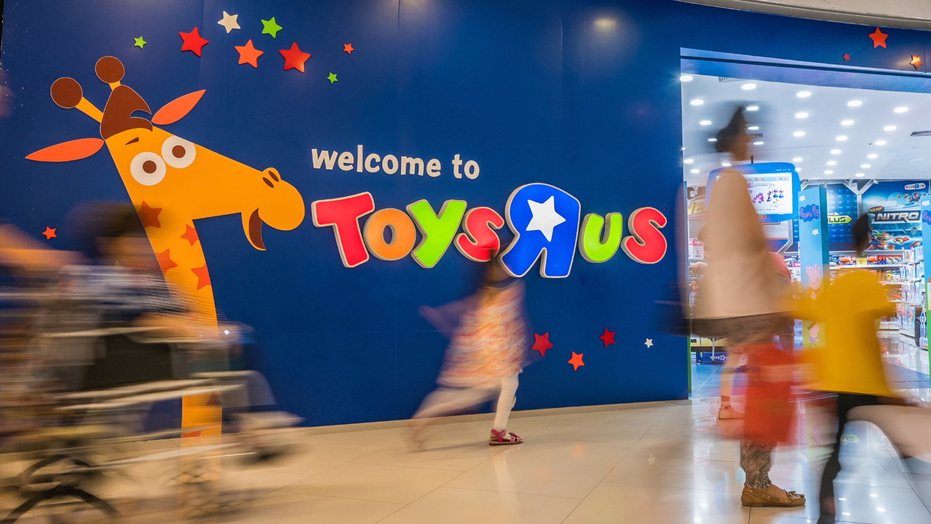 Toys "R" Us mall entrance with a Geoffrey the Giraffe mural.