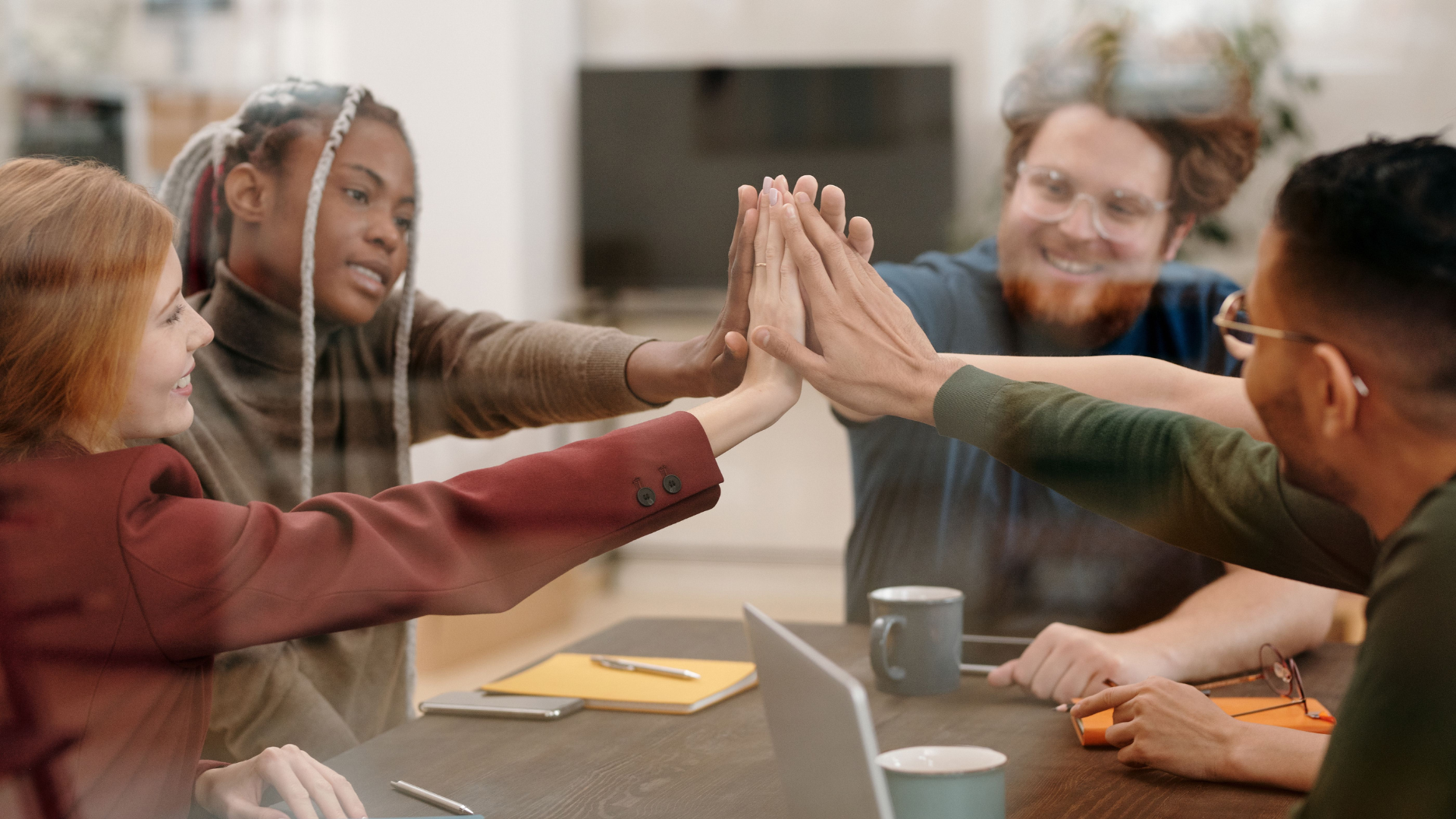 A diverse group of colleagues in an office setting who are happy, reflecting how creative housing solutions are freeing up money for loans, travel, and everyday life.