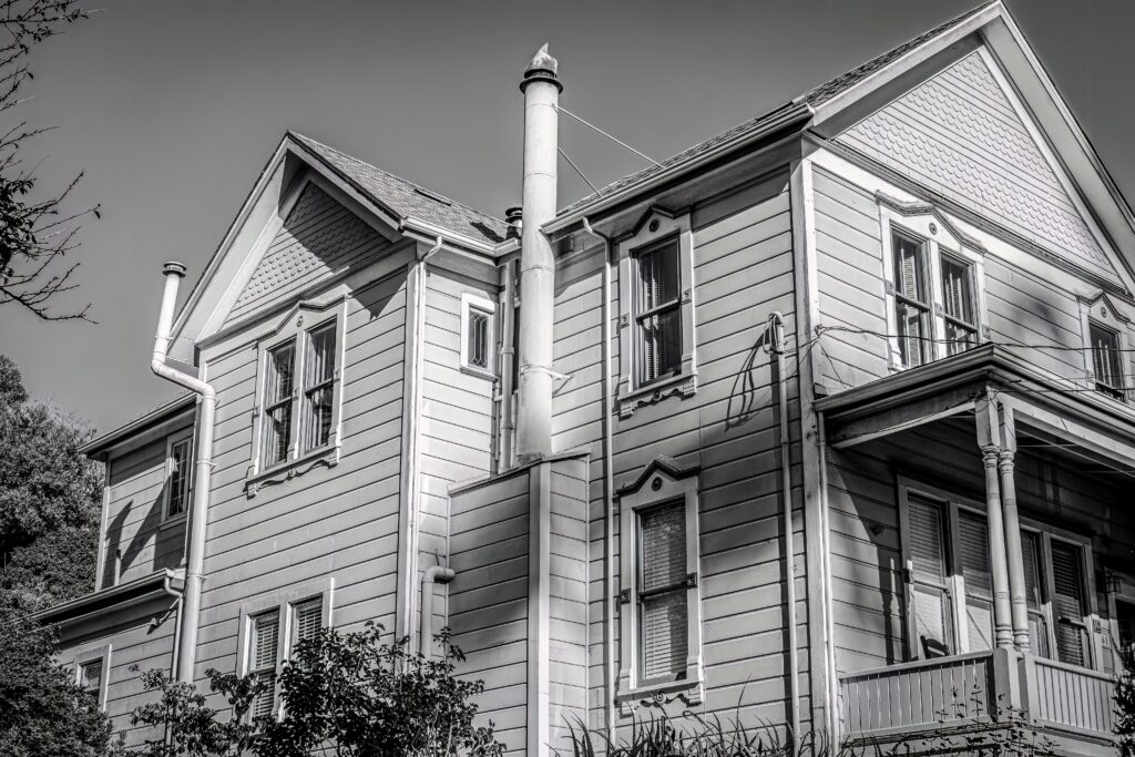 Black-and-white photograph of a large older house, illustrating the type of building often associated with reports of unexplained or “haunted” experiences.