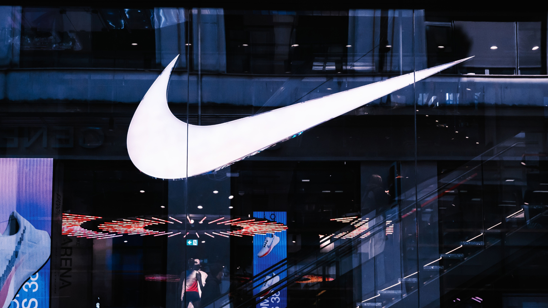 Stylish architectural facade featuring illuminated signage and glass panels, capturing a modern vibe.
