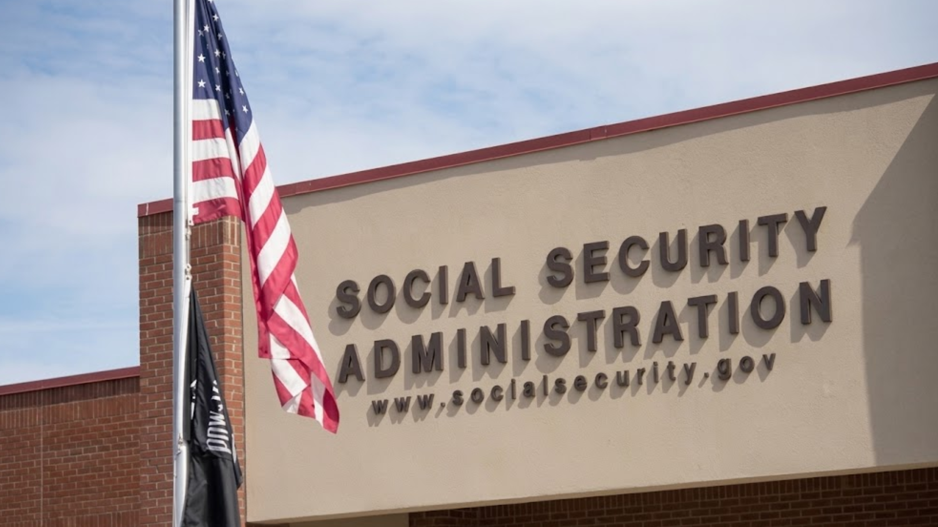 An exterior view of a Social Security Administration building with an American flag flying out front.