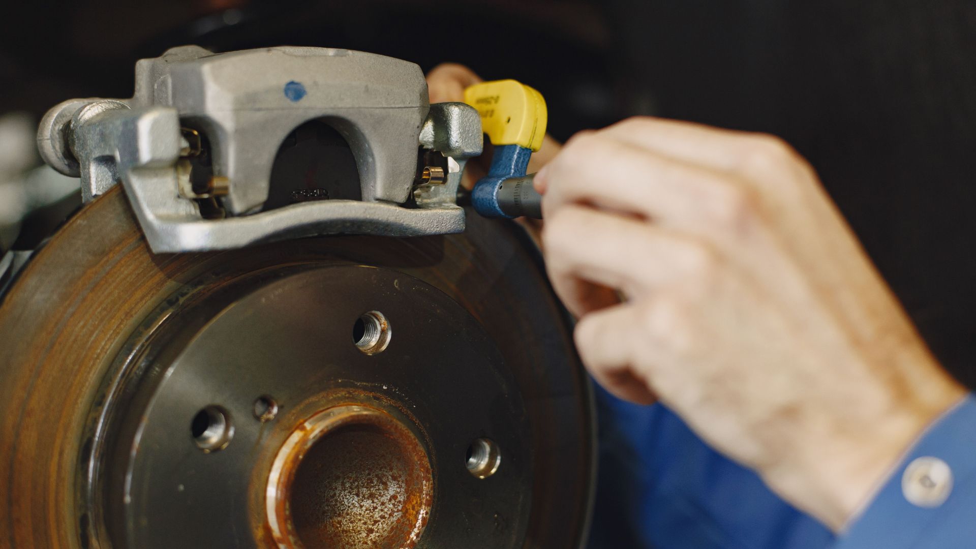 Mechanic handling wiring connector on brake caliper.
