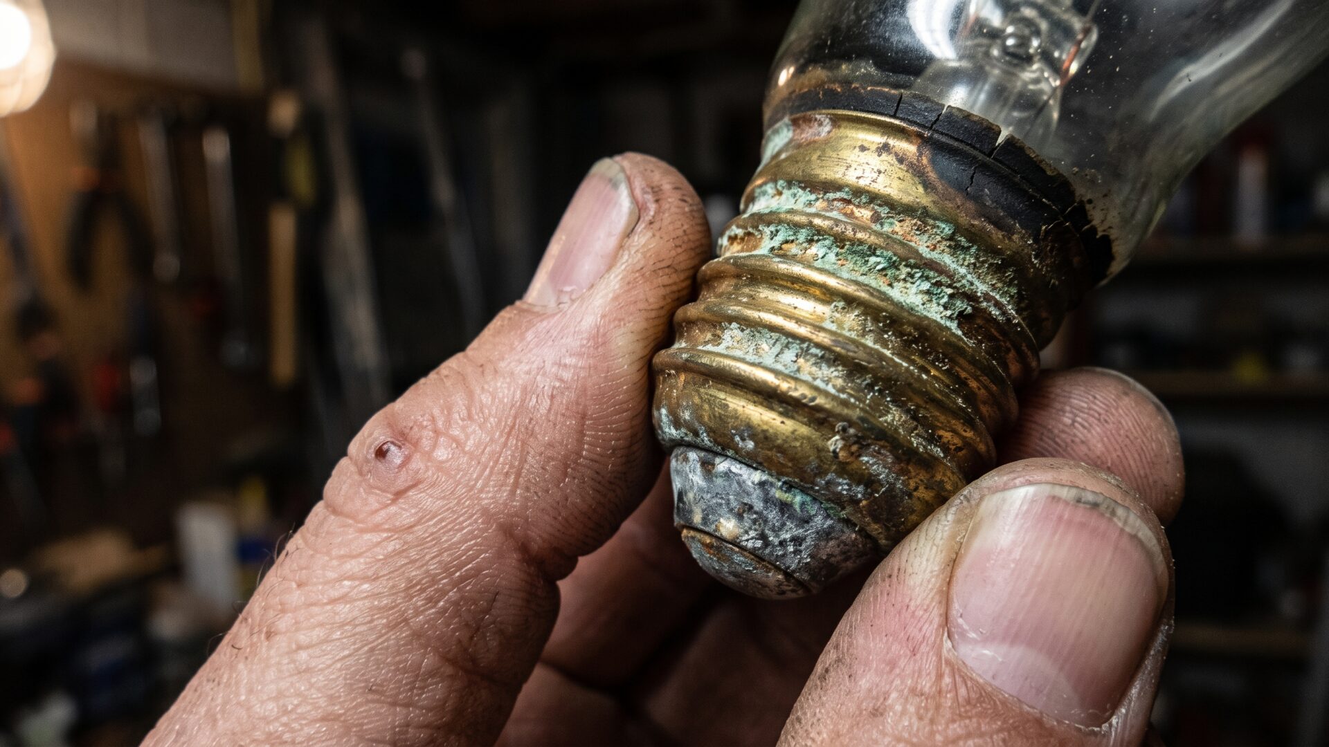 Macro on corroded metal contacts at a bulb base, the compounding corrosion damage slide 3 describes.